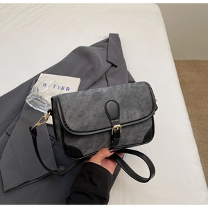 Detail of adjustable leather strap and vintage denim crossbody bag with metal buckle