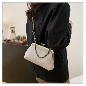 Detail of grey crocodile pattern doctor bag with gold metal frame and beaded chain strap