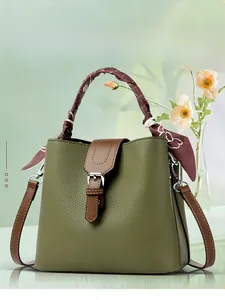 Detailed view of an olive green bucket bag with lychee texture and silk scarf handle