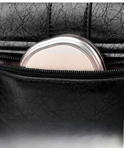 Détail du sac en cuir plissé noir souple avec fermeture éclair et accessoire rose