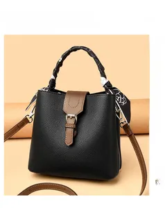 Close-up of litchi texture bucket bag with silk scarf handle and leather strap