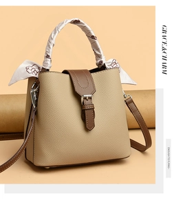 Detail of lychee pattern beige bucket bag with brown trim and floral silk scarf handle