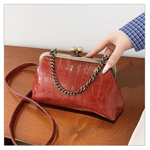 Detailed macro view of red crocodile pattern leather with vintage bead clasp and metal chain