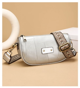 Detail of silver crescent crossbody bag with bohemian woven wide strap and vintage hardware