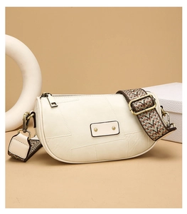 Detail of cream half-moon crossbody bag with wide geometric pattern fabric strap