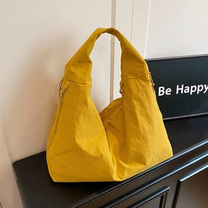 Large capacity bright yellow nylon tote bag in crescent shape with wide shoulder strap