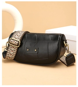 Detail of black leather crossbody bag with retro geometric woven shoulder strap