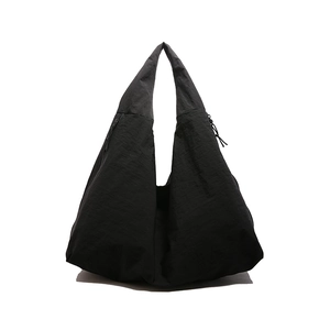 Minimalist large black nylon hobo tote bag with pleated texture on white background