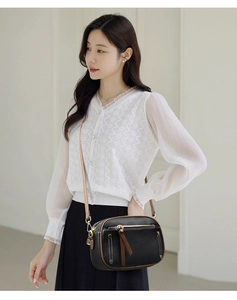 Detailed close-up of a contrast stitch crossbody bag worn by a model in a casual setting