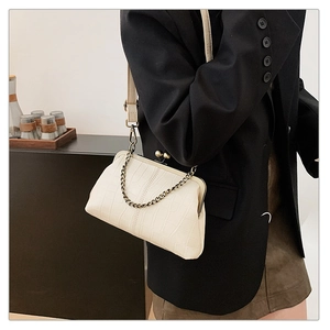 Detail of cream stone pattern crossbody bag with vintage metal frame and gold chain