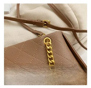 Vue macro de la texture en cuir matelassé marron et de la chaîne dorée du sac à main