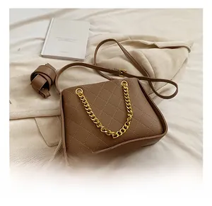 Détail du sac matelassé marron avec chaîne dorée et finition en similicuir élégante