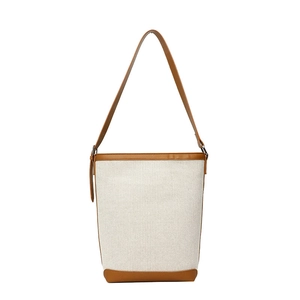 Chic beige canvas and brown leather bucket bag with adjustable crossbody strap