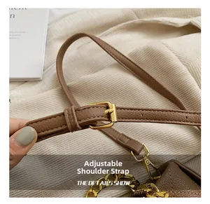 Détail de la bandoulière réglable en cuir marron avec boucle dorée et mousqueton