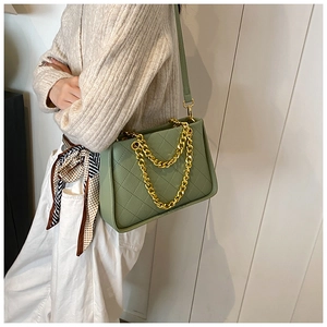 Vue détaillée du sac en cuir vert matelassé avec une grosse bandoulière chaîne dorée