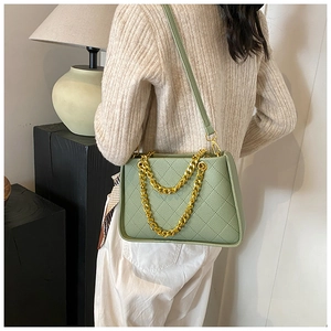 Détail du sac matelassé vert clair avec chaîne dorée et texture en cuir fine