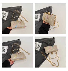 Détails de la pochette pailletée champagne avec imprimés plumes et fermoir perle
