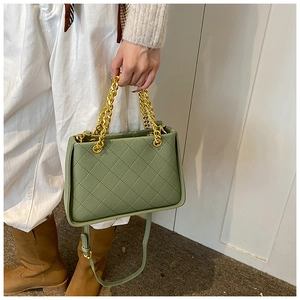 Détail d'un sac à bandoulière matelassé vert avec chaînes dorées et bandoulière réglable