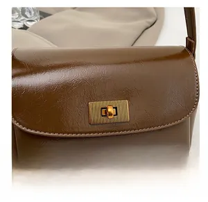 Detail of the high-quality gold rectangular twist lock on a vintage brown leather bag