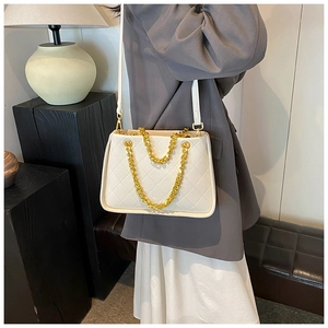 Sac bandoulière matelassé crème avec chaîne dorée sur un décor de style de vie