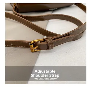 Close-up of brown glossy leather adjustable shoulder strap with gold metal buckle