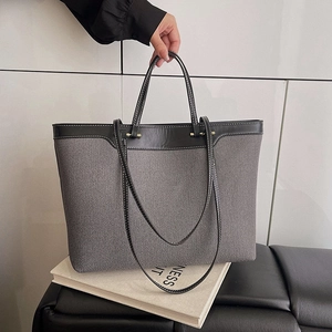 Large denim tote bag in grey fabric with black leather trim and white contrast stitching