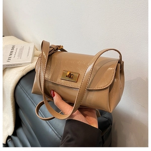 Detail of caramel patent leather crossbody bag with rectangle metal twist lock closure