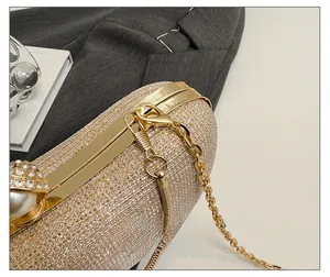 Détail de la pochette pailletée champagne avec fermoir perle et bandoulière chaîne dorée chic