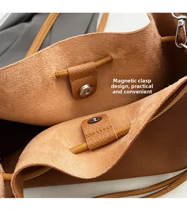 Detail of the brown bucket bag showing the secure magnetic closure and pebble leather texture