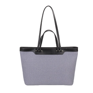 Large gray-blue canvas tote bag with black leather trim and contrast stitching details