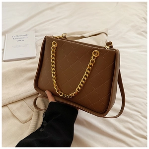 Détail du sac matelassé marron avec chaîne dorée et texture en cuir grainé élégante