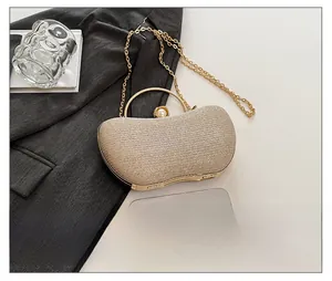 Détail d'une pochette à paillettes champagne avec poignée dorée et fermoir perle