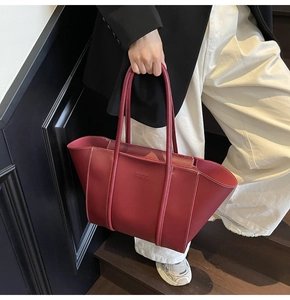 Détail du cabas bordeaux montrant le cuir mat vintage et les surpiqûres contrastées