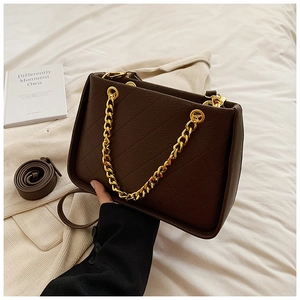 Détails du sac matelassé marron foncé avec chaîne dorée et cuir synthétique texturé