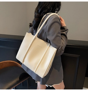 Détail d'un sac cabas en cuir beige avec logo Fashion embossé et doubles bandoulières
