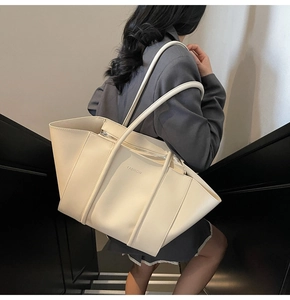 Détail du grand sac cabas beige avec lettrage en relief et double bandoulière souple