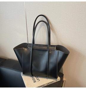 Gros plan du sac fourre-tout noir avec surpiqûres blanches et logo en relief
