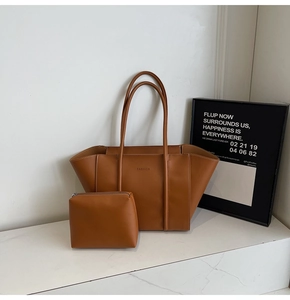 Détail du sac cabas vintage caramel et sa pochette sur une surface en marbre chic