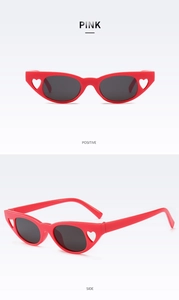 Detail view showing red cat-eye sunglasses with heart cutout design and dark lenses