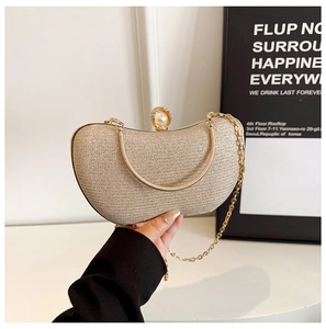 Détail de la pochette dorée avec fermoir en perles et strass et bandoulière chaîne