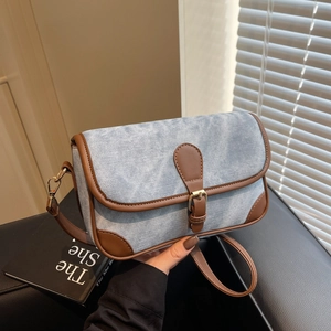Vintage denim shoulder bag with brown leather trim and metal buckle closure