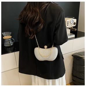 Détail du sac de soirée à paillettes argentées avec chaîne dorée et fermoir perle chic