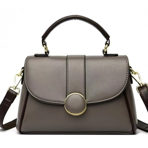 Sac à main en cuir souple gris avec bandoulières marron et boucle dorée ronde
