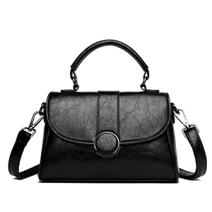 Sac bandoulière noir minimaliste à texture galet avec boucle argentée et poignée ronde