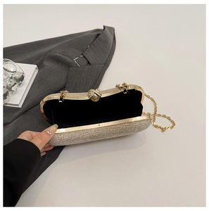 Détail de la pochette dorée à paillettes avec fermoir perle et bandoulière chaîne