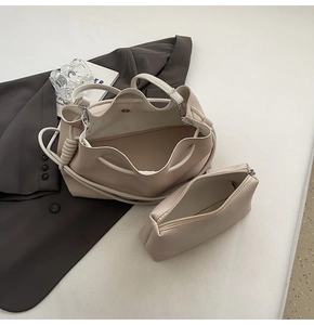 Detail view of beige leather bucket bag with rope handle and matching inner pouch