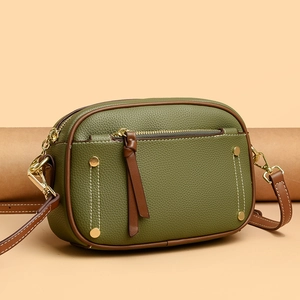 Olive green faux leather crossbody camera bag with gold rivets and brown strap