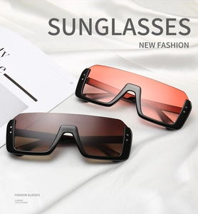 Detailansicht der Oversize-Shield-Sonnenbrille mit Nieten auf Seide und Modemagazin