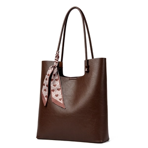 Deep brown faux leather tote bag with litchi texture and heart pattern scarf on white background