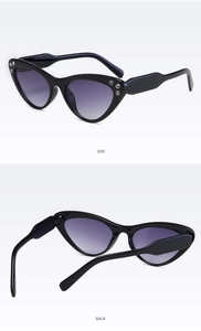 Dettaglio occhiali da sole cat eye con lenti viola sfumate e decorazioni in strass